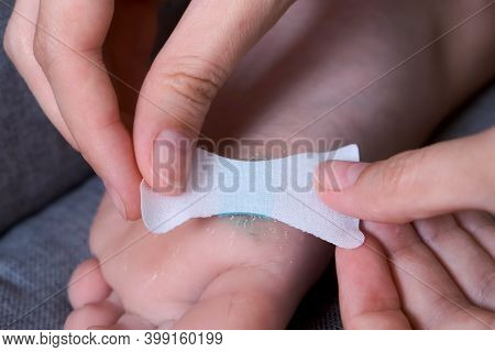 Mother Is Sticking Plaster On Wound On Childs Foot With Antibacterial Powder, Closeup View. Motherho