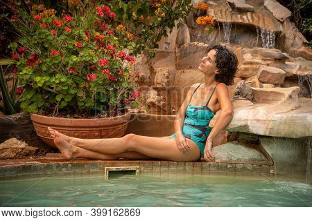 Brunette Sits By Water Feature Cocking Head