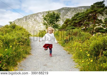 Cute Little Happy Toddler Girl Running On Nature Path In Glenveagh National Park In Ireland. Smiling