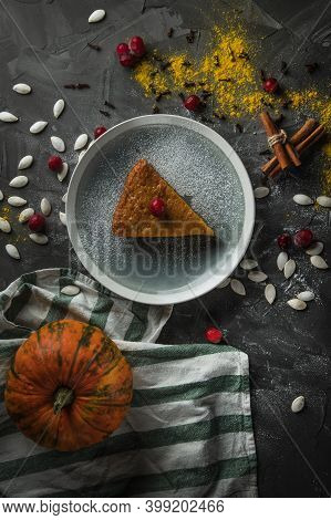 A Delicious Piece Of Pumpkin Pie On A Stone Table, Surrounded By Cinnamon Sticks, Cranberries. In Th