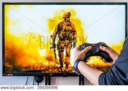 Woman Holding A Generic Controller And Playing Popular Video Game Call Of Duty On A Television And P