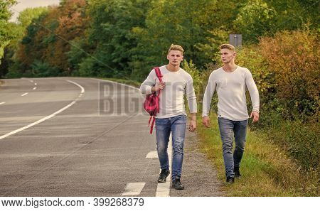Pick Spot Where Car Can Easily Pull Aside. Men Backpack Walking Road. Twins Walk Along Road. Adventu