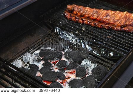 Close-up Of Bbq Roast And Smoked Pork Spareribs Glazed With Sauze On The Hot Charcoal Grill With Fla