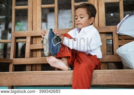 Indonesian Primary School Student Getting Ready To School In The Morning