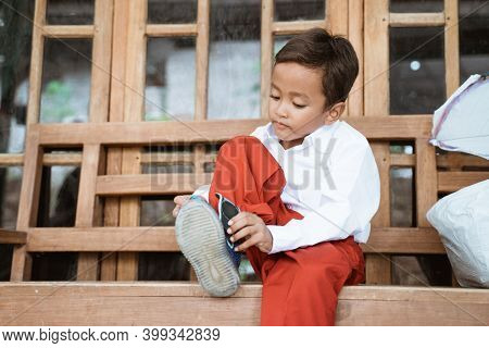 Indonesian Primary School Student Getting Ready To School In The Morning