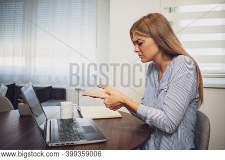 Young Woman Is Working From Home. She Is Having Pain In Palm Of Hand.