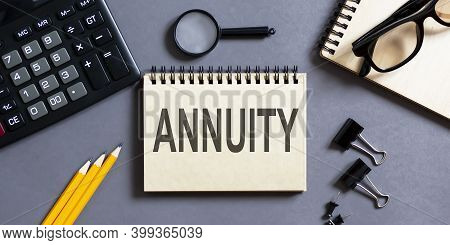 Notepad With Inscriptions Annuity On A Grey Background With Office Tools . Business