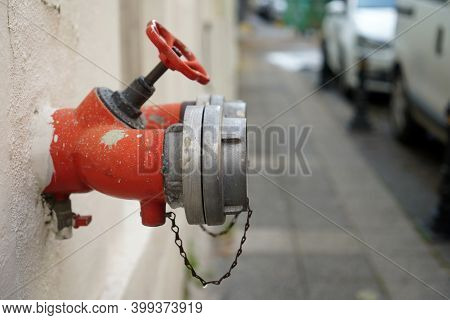A Dark Red Fire Hydrant Sits Inside An Old Wall