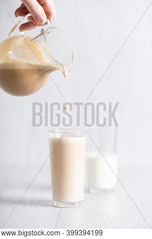 Dalgon Brown Coffee Mixture Is Poured From The Decanter Into A Glass Of Milk. Milkshake With Instant
