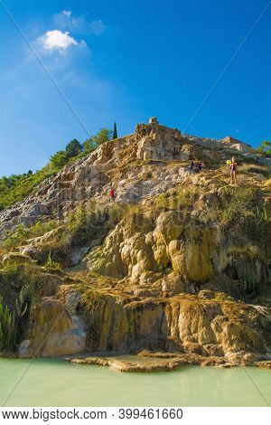 Bagno Vignoni, Italy - September 3rd 2020. Tourists and locals enjoy the natural hot spa springs just outside the historic village of Bagno Vignoni, in Val d\'Orcia in Siena Province, Tuscany
