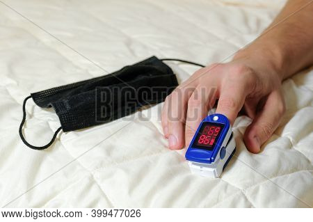 A Pulse Oximeter On A Male Finger Used To Measure The Oxygen Level In The Blood. A Person Using An O