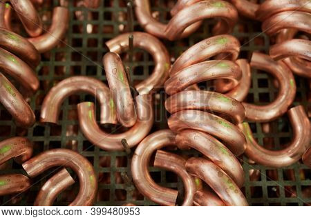 Sections Of Copper Pipes Bent On Special Equipment, At An Industrial Enterprise, In A Workshop, As P