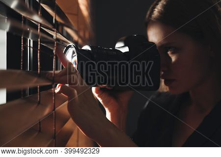 Private Detective With Camera Spying Near Window Indoors