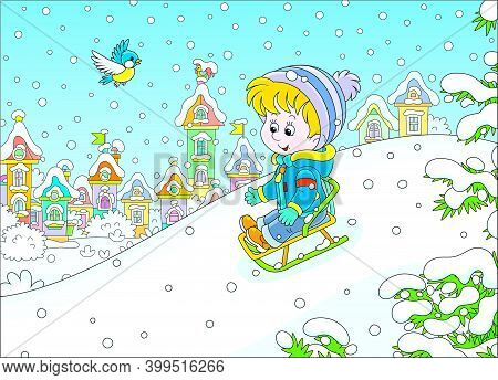 Happy Little Boy Sledding Down A Snow Hill On A Playground In A Snowy Park On A Beautiful Frosty Day