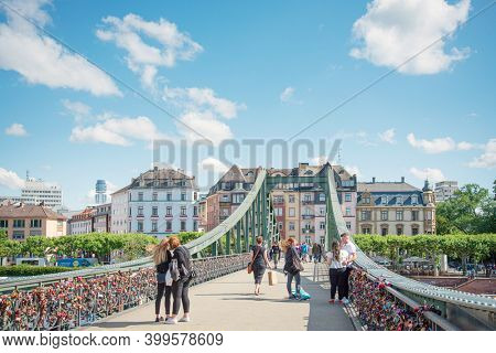 Frankfurt, Germany - June 12, 2019: River view of The Eiserner Steg. The Eiserner Steg is a pedestrian bridge in Frankfurt am Main built in 1868. City skyline in Frankfurt, Germany. 