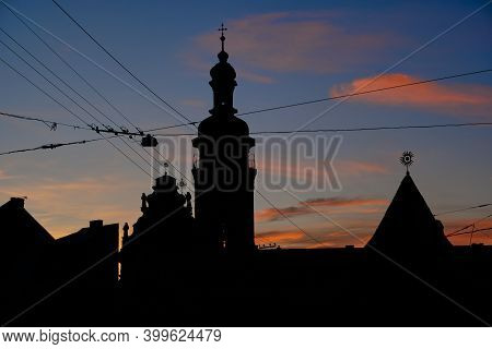Silhouettes Of Evening Lviv. View On Hlyniany Gate And Bernardine Church. Ancient City Walls.