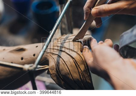 Close-up View Of Female Hands Gently Handling A Clay Whale In Workshop.
