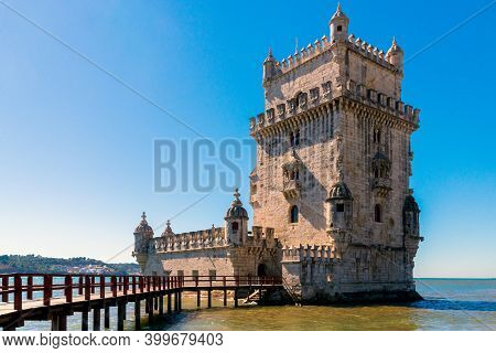 Scenic Belem Tower And Wooden Bridge Miroring With Low Tides On Tagus River. Torre De Belem Is Unesc