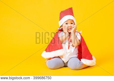 Asian Little Cute Child Girl Smile Face, A Kid Dressed In Red Santa Claus Hat The Concept Of Holiday