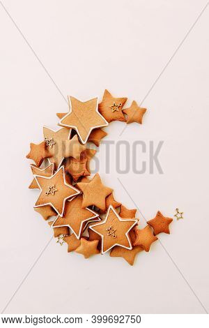 Christmas Ginger Cookies In The Shape Of Stars. Scattered Cookies In The Shape Of A Moon On A White 