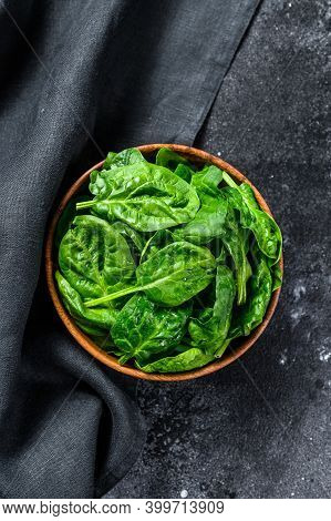 Fresh Spinach Leaves In A Wooden Bowl. Black Background. Top View