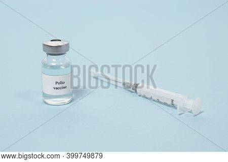 Polio Vaccine And Syringe On A Blue Background. Vaccination And Prevention Poliomyelitis. Infantile 