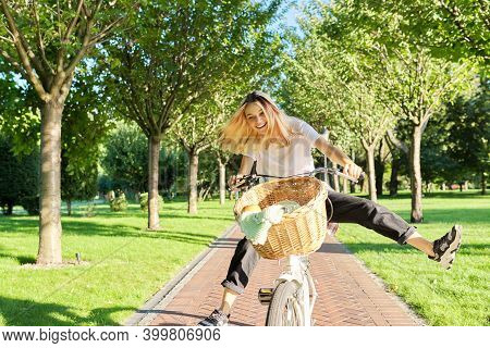 Happy Young Woman Riding Bike On Road In Park, Beautiful Hipter Teenager Having Fun And Laughing.