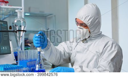 Laboratory Scientist Working In Modern Lab With Test Tubes And Micropipette. Team Of Chemists Examin