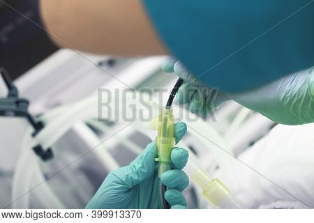 Doctor With An Assistant Perform An Endoscopic Procedure On A Patient On Mechanical Ventilation.