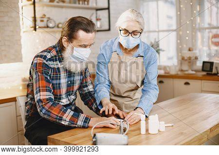 Senior Woman And Man At Home Meassure Blood Pressure