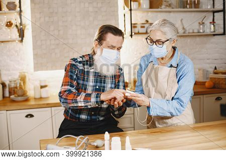 Senior Woman And Man At Home Meassure Blood Pressure
