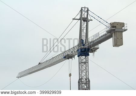Tower Crane Works At A Construction Site Against The Blue Cloud Winter Sky. Stock Photo With Empty S