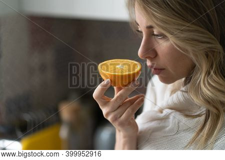 Sick Woman Trying To Sense Smell Of  Half Fresh Orange, Has Symptoms Of Covid-19, Corona Virus Infec