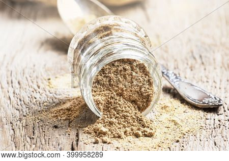 Ground Ginger In Glass Jar And Fresh Ginger Root, Vintage Wooden Kitchen Table Background, Selective