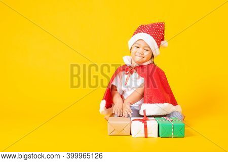 Asian Little Cute Child Girl Smile Face, A Kid Dressed In Red Santa Claus Hat The Concept Of Holiday