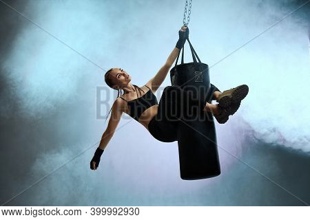 Fit Beautiful Woman With Boxing Bandages And Punching Bag On Studio Smoke Background. Full Lenth