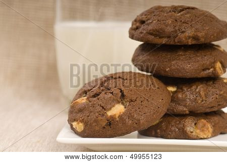 Fresh baked triple chocolate chip cookies with a glass of milk