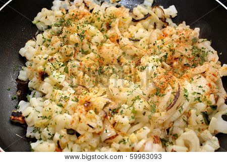 Raw Potatoes And Onions Frying In A Pan
