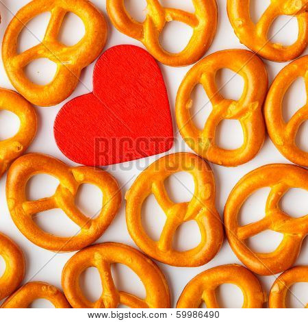 Valentine's Day Background Pretzels Pattern And Red Heart.