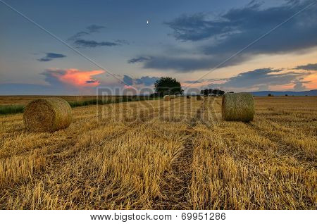 clouds over field with hay