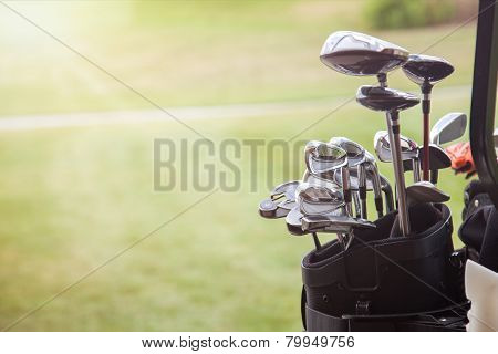Set Of Golf Clubs Over Green Field Background