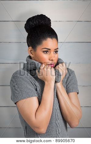 Pretty girl in winter jumper shivering against wooden planks
