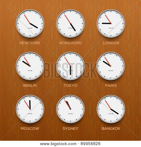 Timezone clocks showing different time, wooden wall background