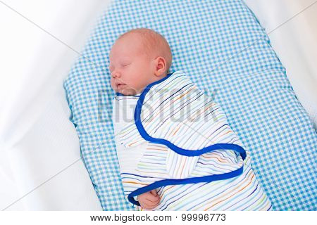 Little Swaddled Baby In White Bed