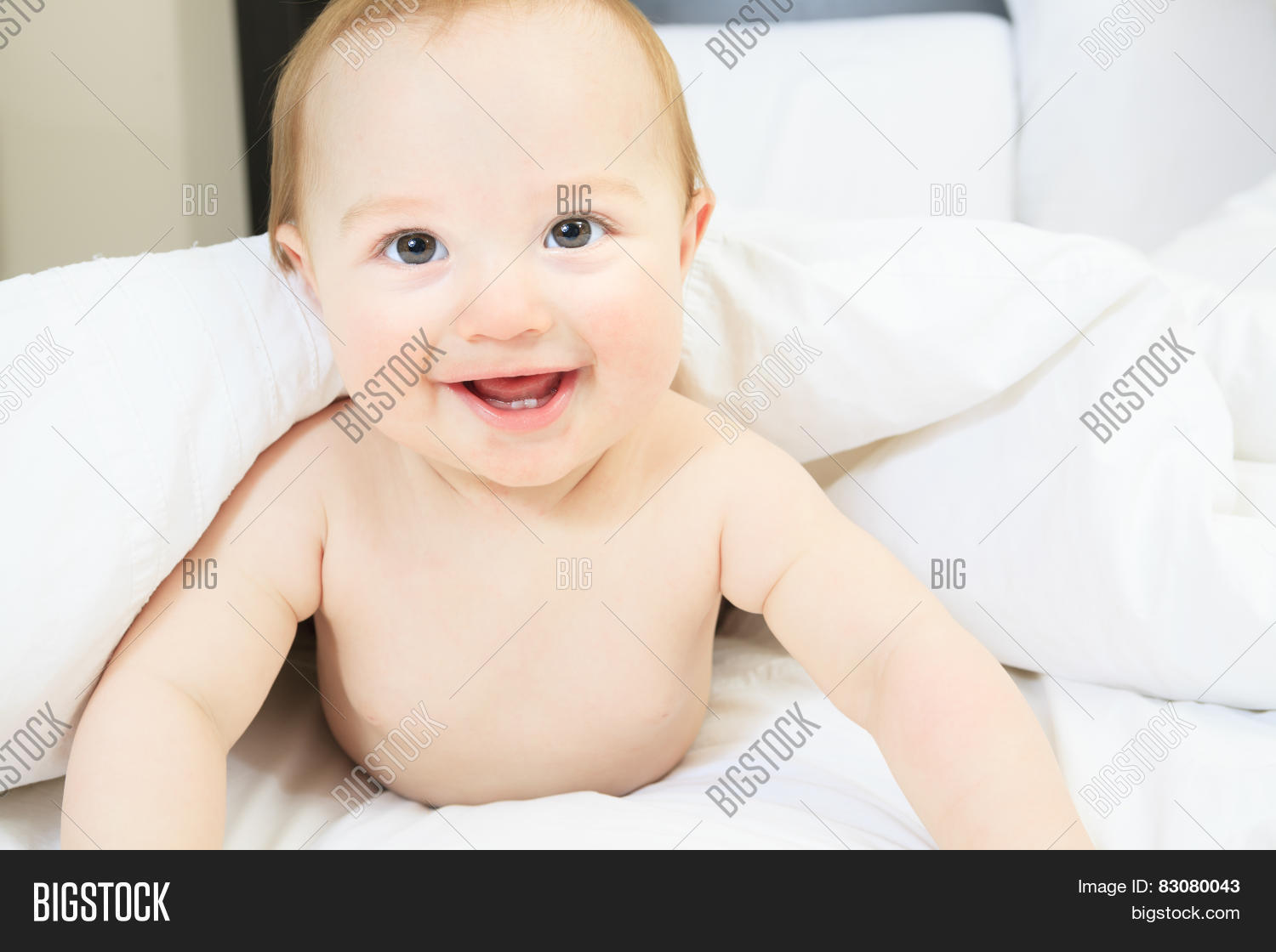a baby boy playing on the parent bed