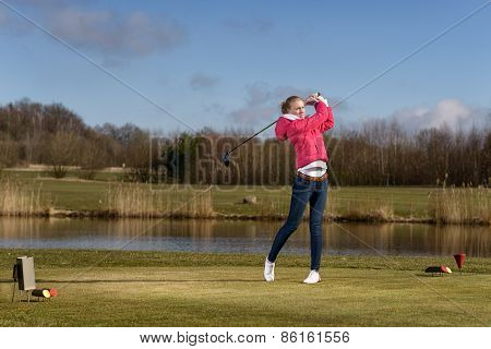 woman golfer hitting a golf ball on the fairway