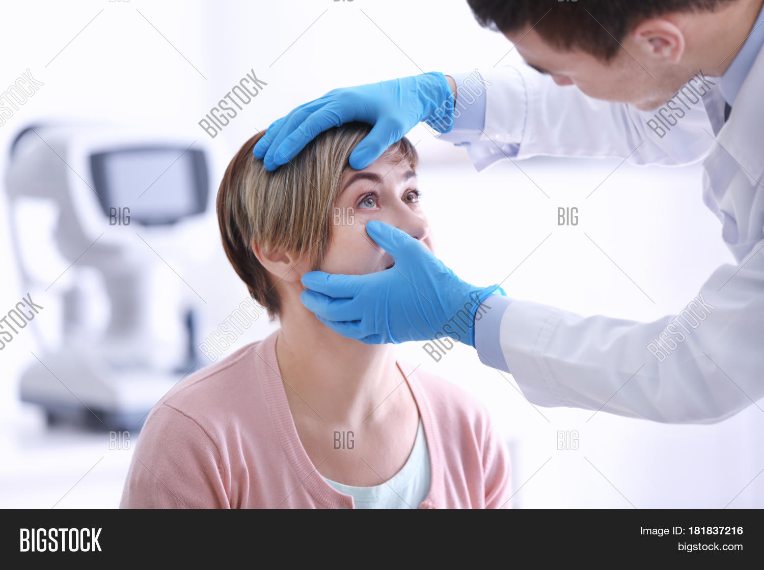 ophthalmologist examining eyes of mature woman in clinic