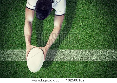 high angle view of man holding rugby ball with both hands