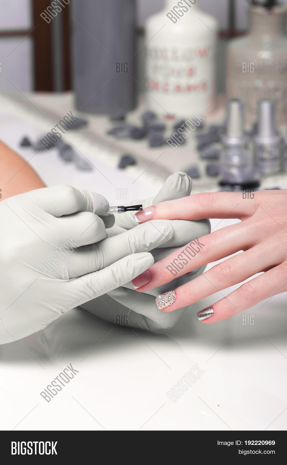 closeup finger nail care by manicure specialist in beauty salon.