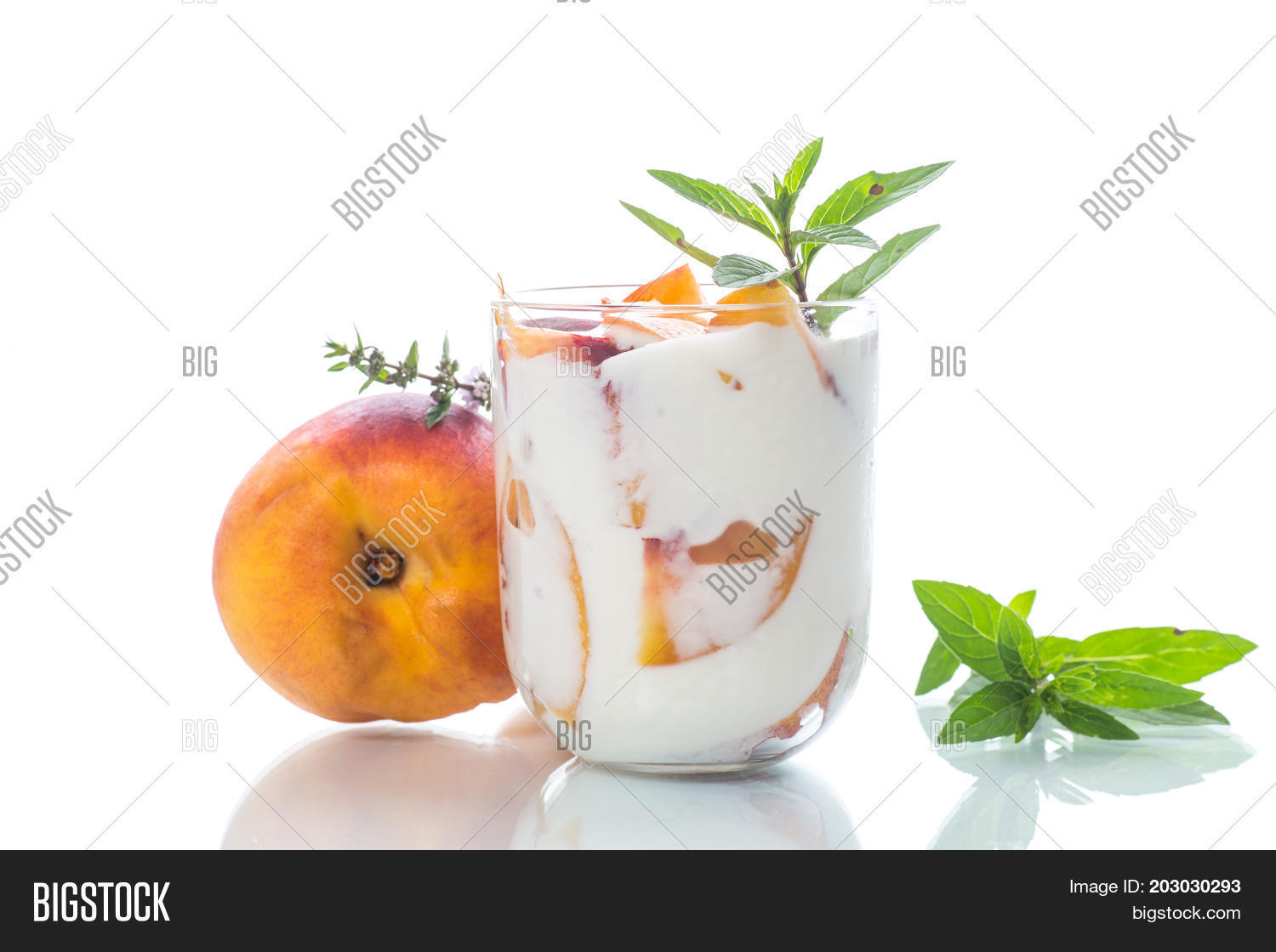 sweet home-made yogurt with pieces of peach in a glass cup